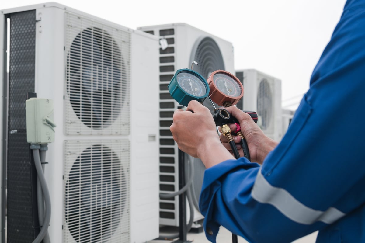 HVAC technician checking air conditioner